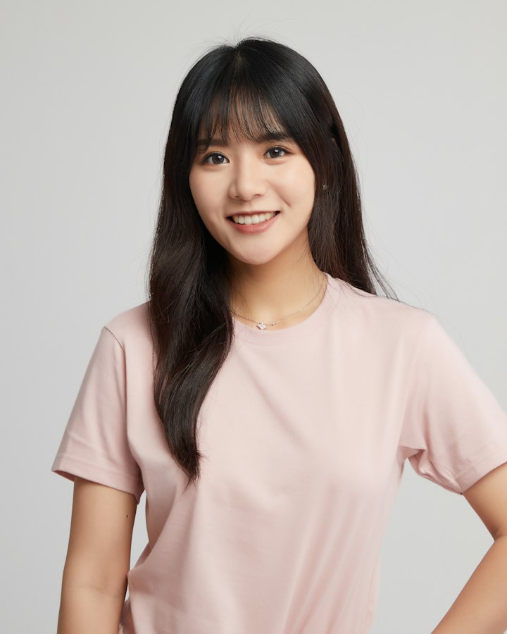 Perempuan berkaos pink tersenyum